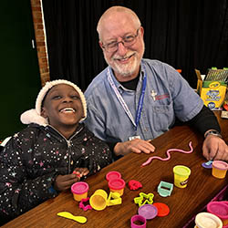 Norm Waggy with child at CDS project