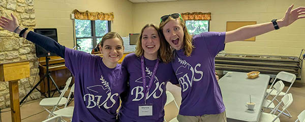 Three people in BVS t-shirts smiling widely