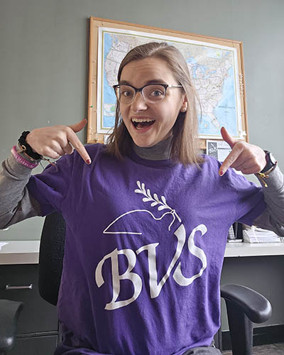 Person pointing to BVS on a purple t-shirt