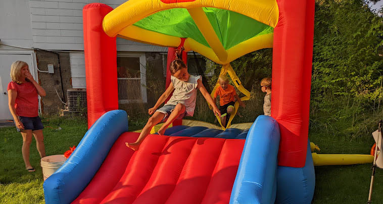 Children bouncing on bouncy slide