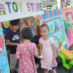 Children in front of a handmade sign that says "Toy store"