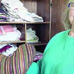 Maureen Waite next to shelf full of fabric