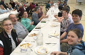 Smiling people sitting at a long table