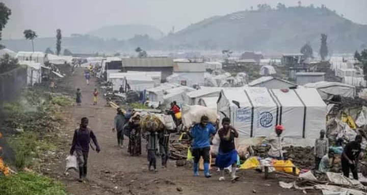 People on a dirt path near tents