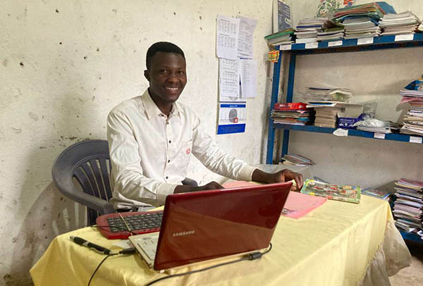 Smiling man sitting in front of a computer