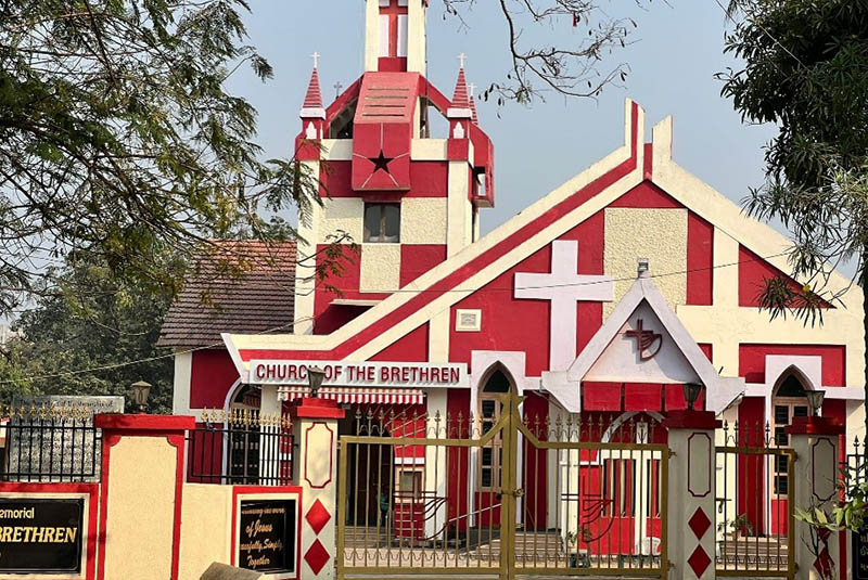 Red and white church building with a sign that says "Church of the Brethren"