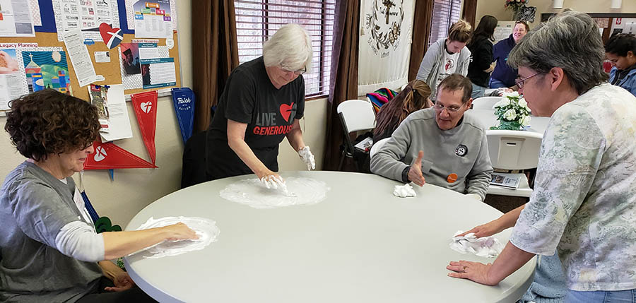 People spreading shaving cream on a table