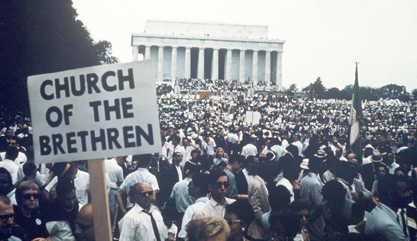 Sign that says "Church of the Brethren" in the midst of a huge crowd in front of the Lincoln Memorial in Washington DC.