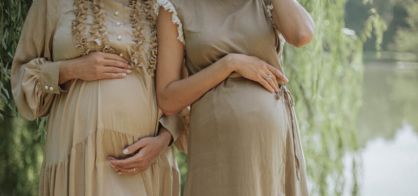 Two pregnant women by a river