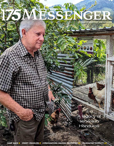 Chet Thomas standing near chickens - Messenger cover July/August 2025