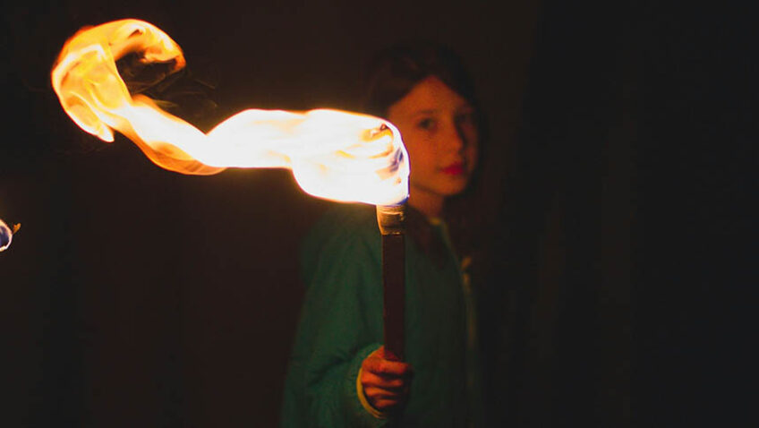 Girl holding torch in the dark