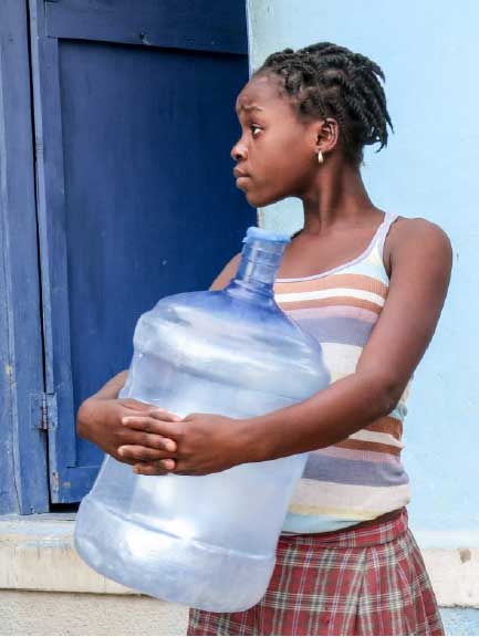 Haitian person with water jug