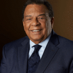 Andrew Young in a dark suit, smiling