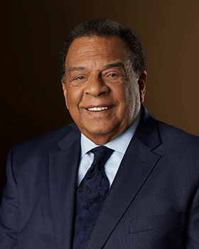 Andrew Young in a dark suit, smiling