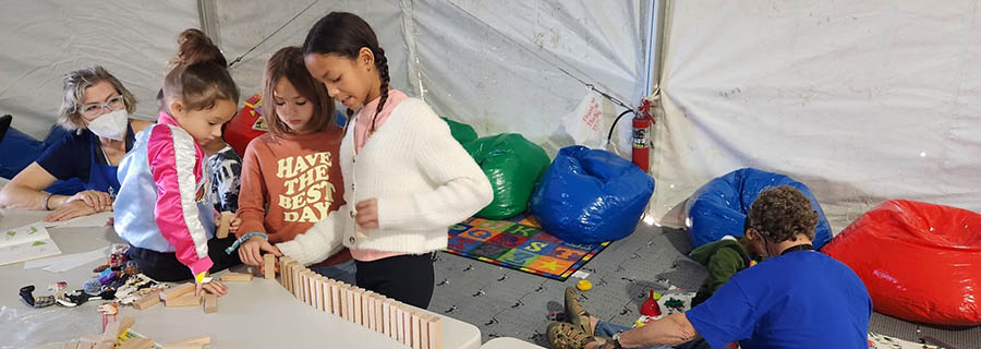 Children setting up blocks in a tent-like structure