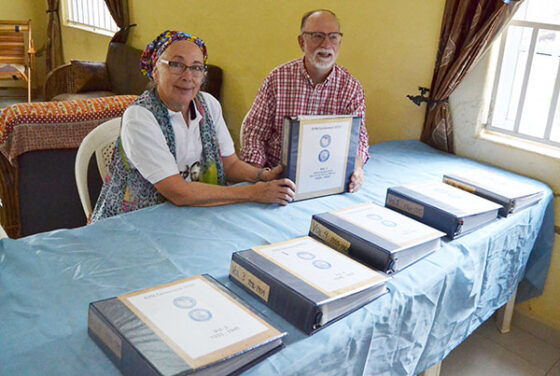 Pat and John Krabacher with the six folders of copies of articles about the history of the mission and the church in Nigeria, which they presented as a gift to the EYN Headquarters staff and Kulp Theological Seminary. The collection was originally put together by the late Ferne Baldwin, who had served as a mission worker in Nigeria for many years. Photo by Cheryl Brumbaugh-Cayfor