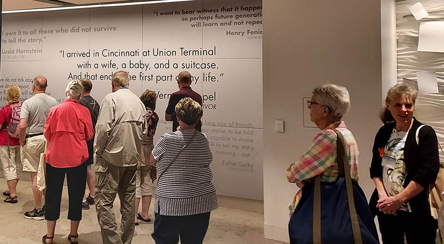 People in front of a large quote on the wall that says "I arrived in Cincinnati at Union Terminal with a wife, a baby, and a suicase. And that ended the first part of my life."