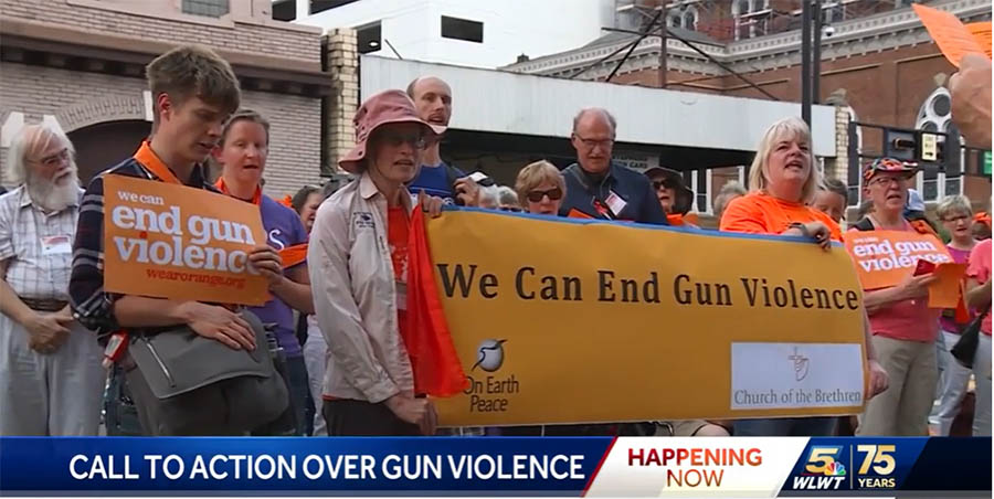 People wearing orange holding a sign "We Can End Gun Violence"