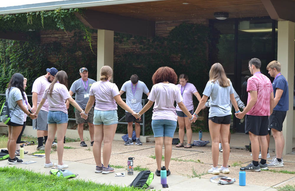 Youth holding hands praying