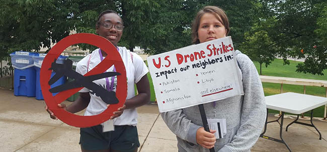 People holding posters protesting drone strikes
