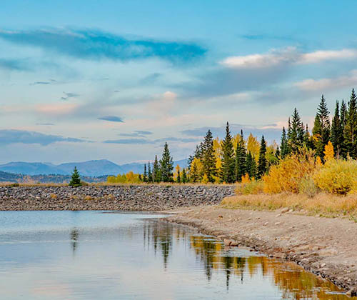 Rocky Mountains and trees behind water