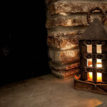 Rustic ceramic lantern shining against a dark background
